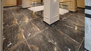 Un vestíbulo espacioso con suelo de mármol, columnas imponentes y apliques de pared.