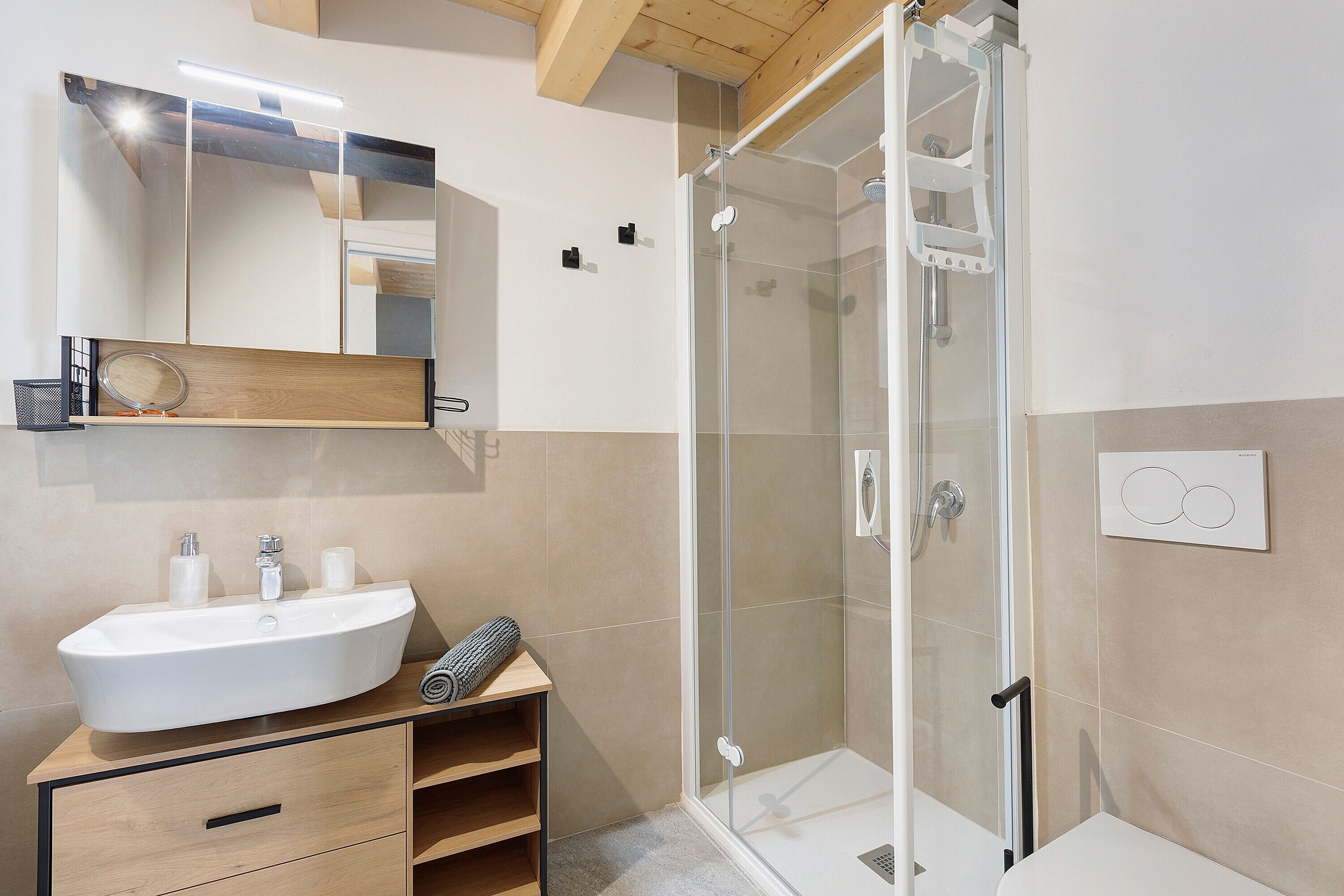 Ein modernes Badezimmer mit Duschkabine aus Glas, einem großen Spiegel und einem Holzbadezimmer-Möbel.