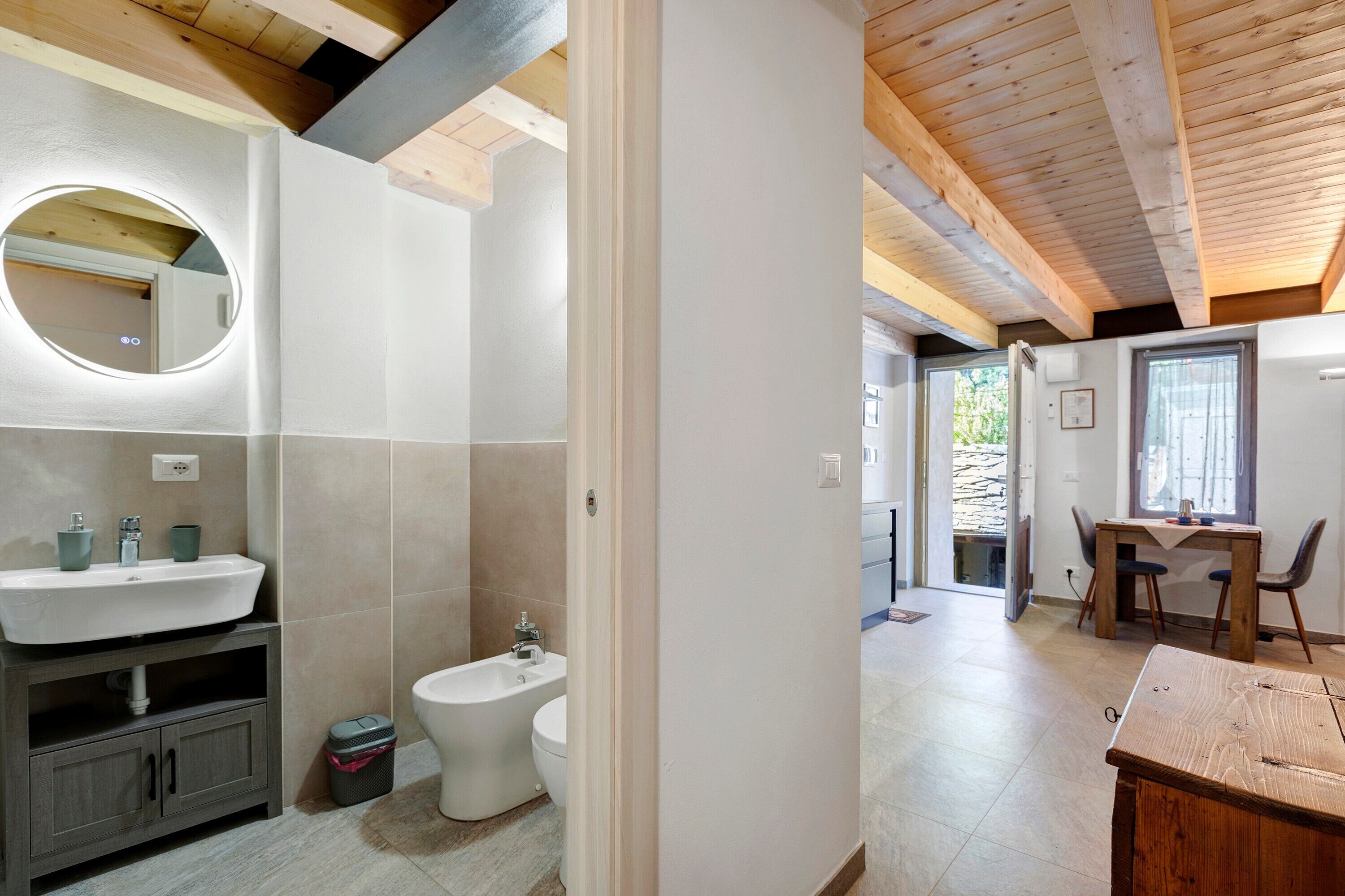 Un bagno con lavandino, WC e specchio.