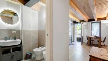 Un bagno con lavandino, WC e specchio.