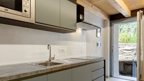 A kitchen with a sink, a microwave, and a stove. - Studio with Private Parking, Shared Garden, and Walk-in Closet (Morgex)