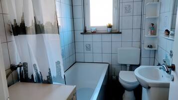 A modern bathroom with a bathtub, toilet, and sink.