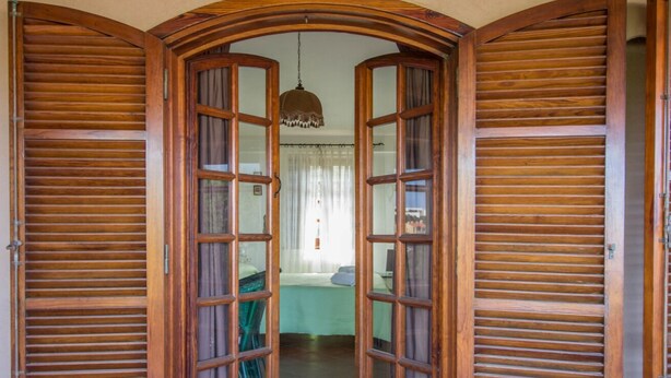 A room with a bed, a chair, and a hanging light fixture. - GuestHost - Porto Cervo Spacious Flat by the Port (Arzachena)