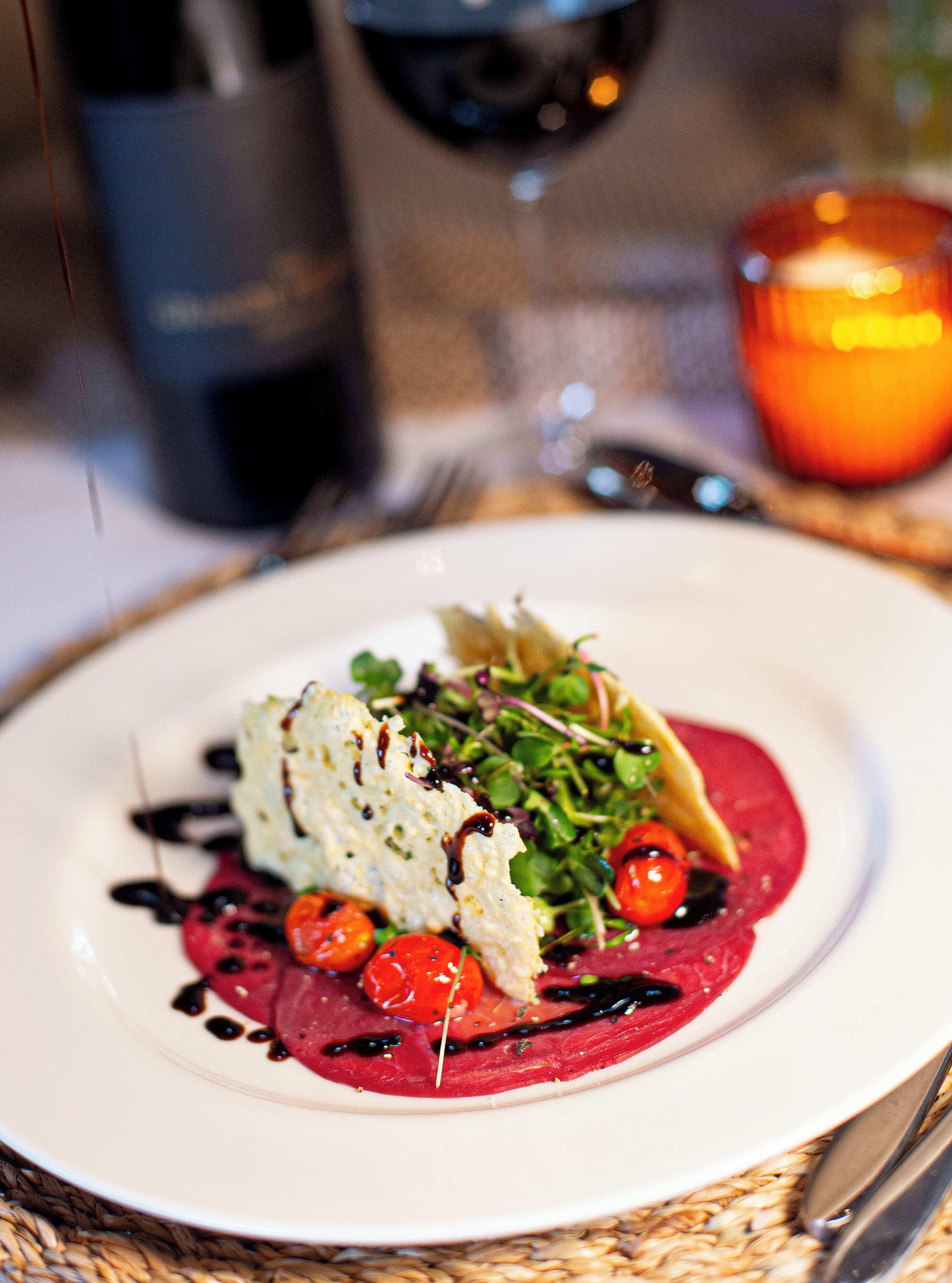 Ein Teller Essen mit Soße, Gemüse und einem Stück Fleisch.