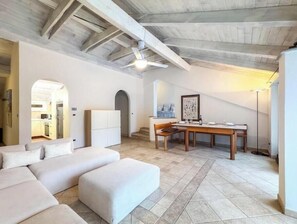 A modern interior with a sofa, a dining table, and a staircase. - Hostdomus - King Suite (Marina di Andora)