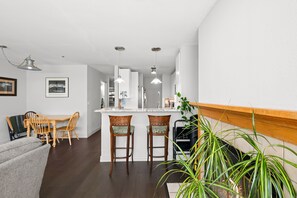 A modern kitchen with white cabinets, a central island with bar stools, and pendant lighting. - New! Boulder Retreat | Pool | Hot Tub | Gym | Explore the City and Mountains (Boulder)