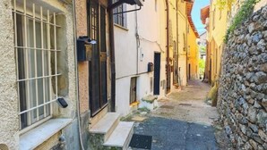 A narrow alleyway with stone walls and buildings on either side. - Hostdomus - The house between olive trees and history (Toirano)