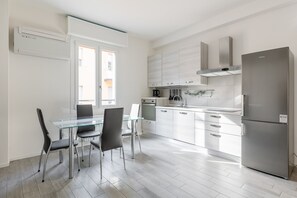 Eine moderne Küche mit einem Glastisch, Edelstahlgeräten und Blick auf die Stadt.