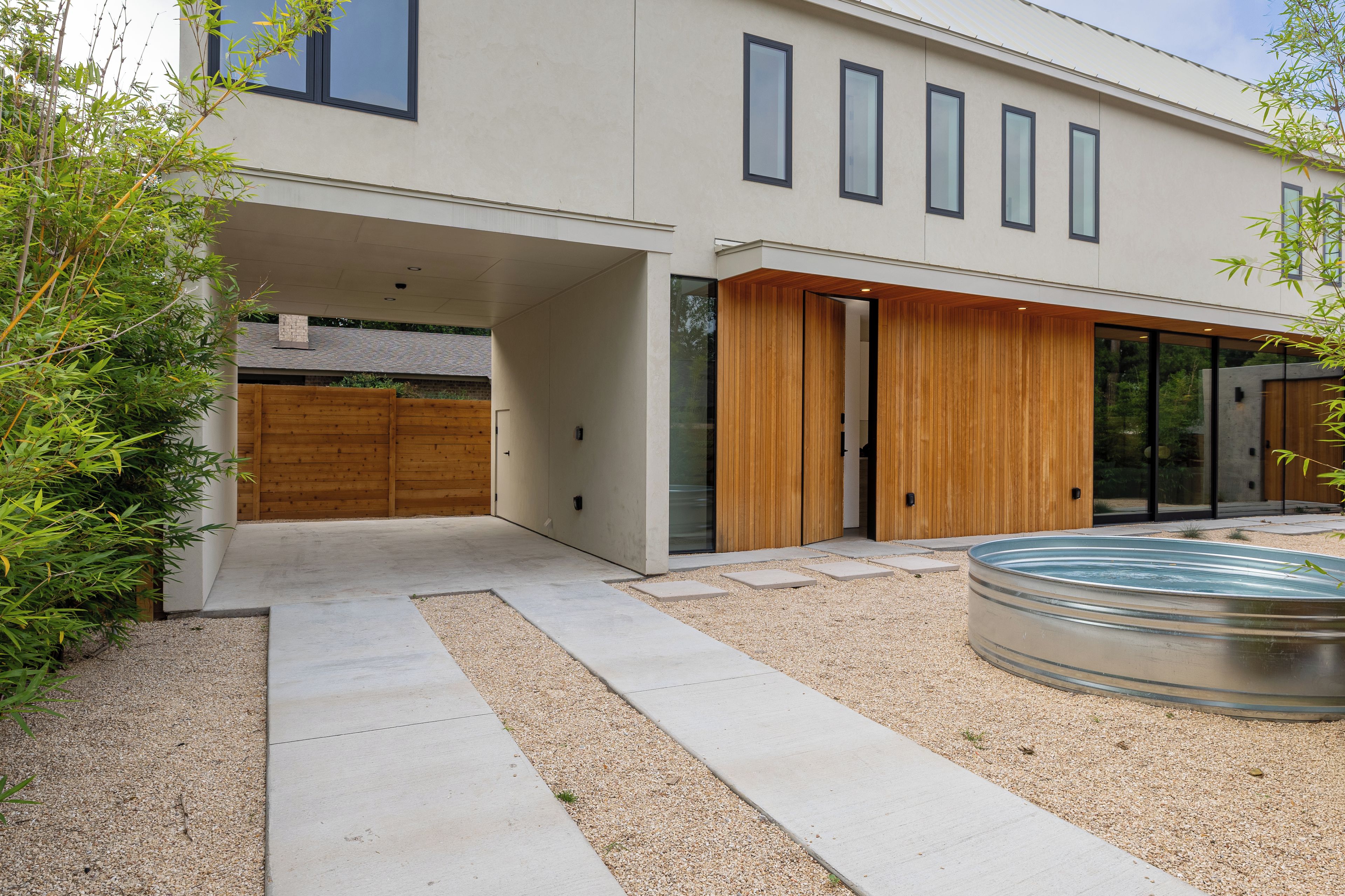 A modern building with a flat roof, large windows, and a wooden door.