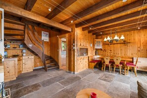 A wooden interior with a staircase, kitchen, dining area, and stone flooring. - Pomme de Pin - authentic and spacious (Haute-Nendaz)
