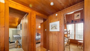 Een houten interieur met een badkamer, een bed en een raam met uitzicht.