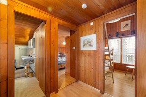 A wooden interior with a bathroom, a bed, and a window with a view. - Pomme de Pin - authentic and spacious (Haute-Nendaz)