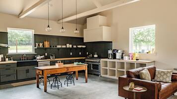 A spacious kitchen with a dining area, a coffee machine, and a sofa.