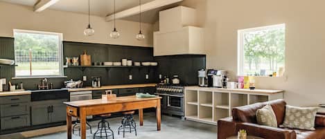 A spacious kitchen with a dining area, a coffee machine, and a sofa.