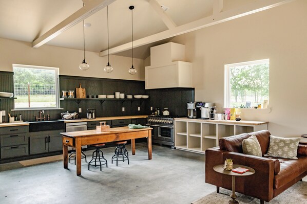 A spacious kitchen with a dining area, a coffee machine, and a sofa.