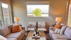 A living room with two sofas, a coffee table, and lamps. - Spacious 4-bedroom ranch-style home 10 min from USAFA with lake & mountain views (Monument)