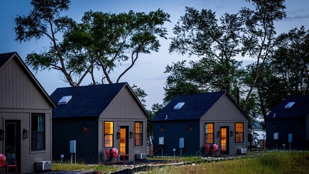 A row of cabins with a pathway leading to them, surrounded by trees and a body of water. - Cozy & Family-Friendly Lake Oasis: Ofuro Tub, King Bed, Bunks & Workspace! (Jewett)