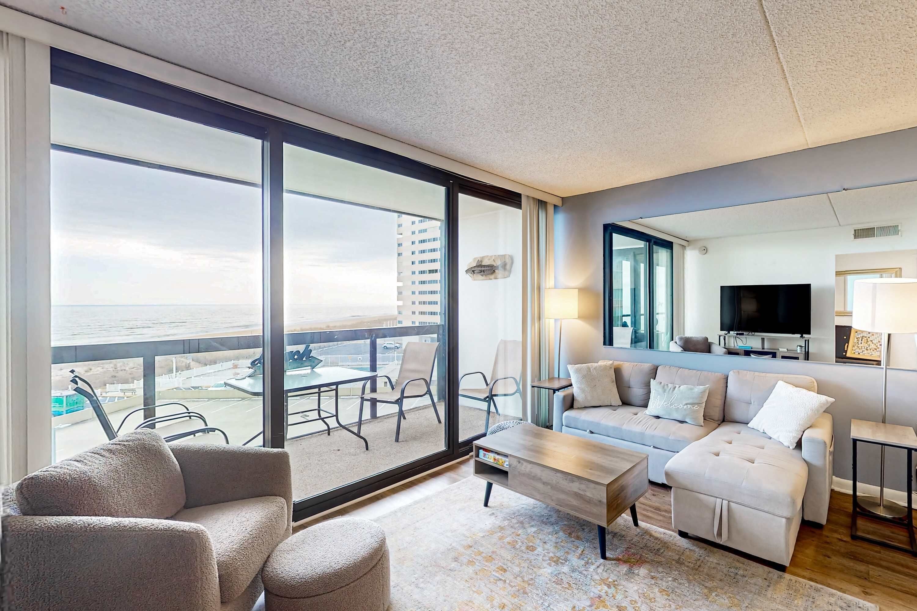 A modern living room with a large window, a sofa, a coffee table, and a TV.