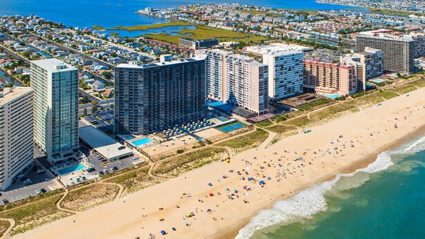 Un paysage urbain côtier avec de grands hôtels, une plage de sable et une vue dégagée sur l’océan.
