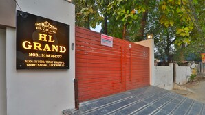 A hotel entrance with a red gate, a signboard with the hotel's name and contact details, and a paved entrance area. - HOTEL O BLUE DIAMOND (Lucknow)