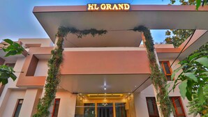 A hotel entrance with a sign reading 'HL GRAND,' a covered entrance, and a glass door. - HOTEL O BLUE DIAMOND (Lucknow)