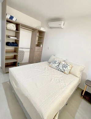 Ein Schlafzimmer mit Bett, Kleiderschrank und Klimaanlage.