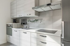 A modern kitchen with a stainless steel refrigerator, built-in oven, and a gas stove. - Mascarella Cozy Studio by Wonderful Italy (Bologna)