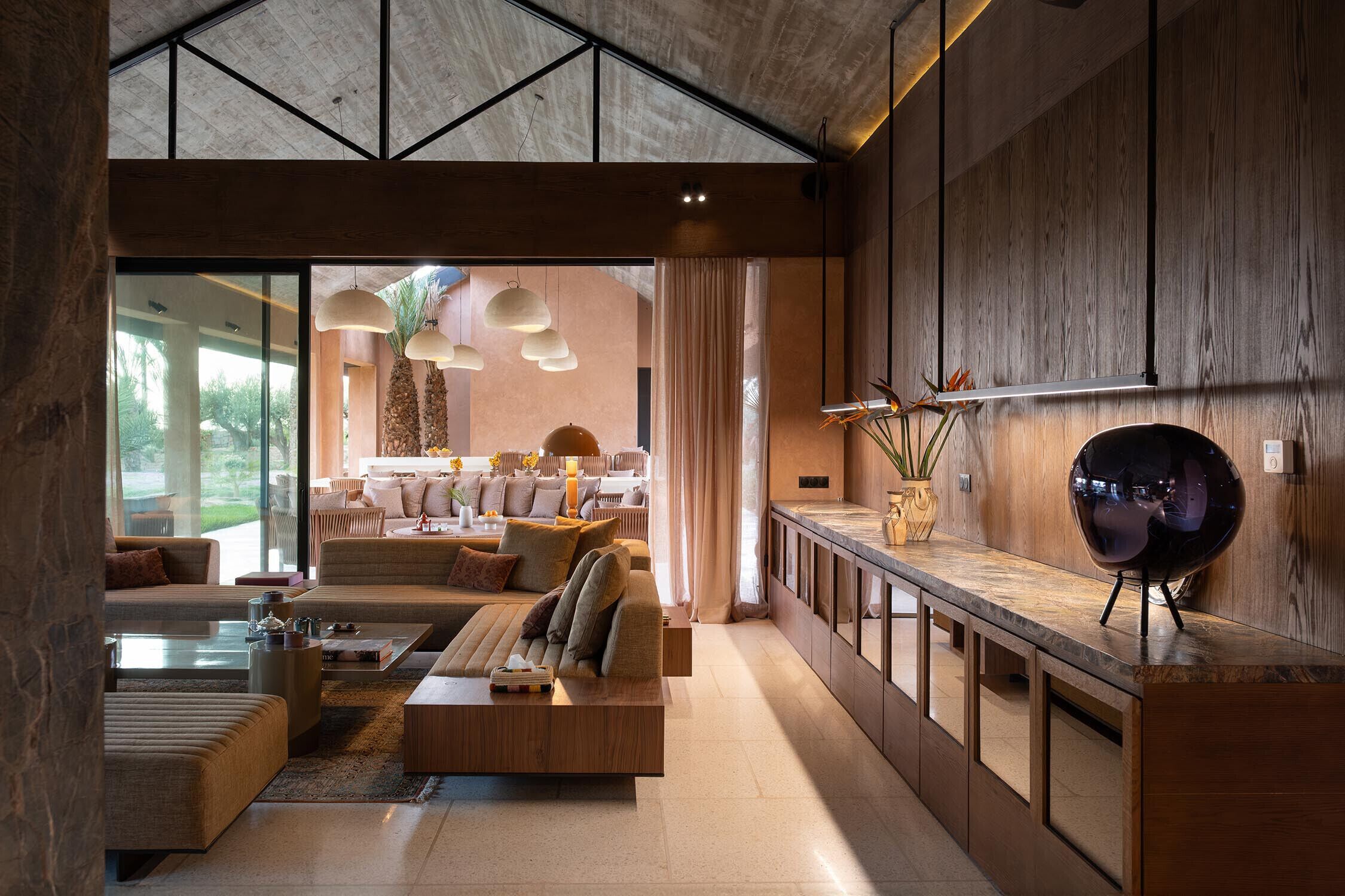 Un salon moderne avec un canapé, une table basse et des luminaires suspendus.