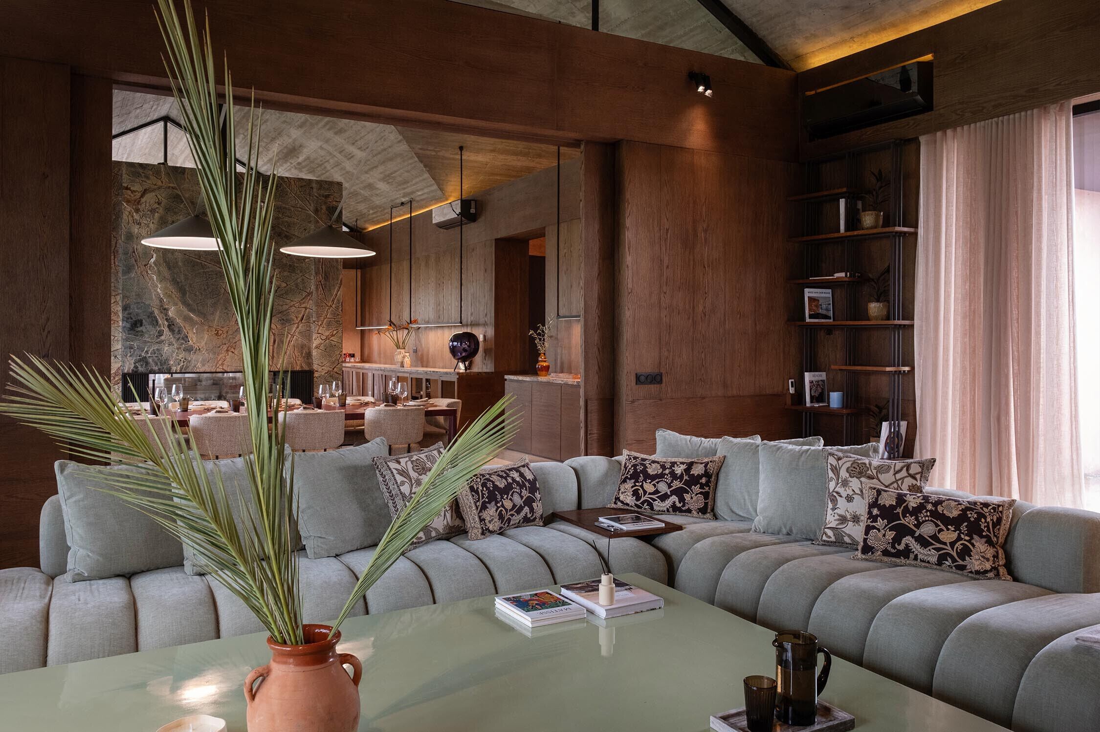 Una sala de estar moderna con un sofá modular, una mesa de centro y una estantería.