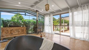 Ein geräumiges Zimmer mit großem Fenster, Kamin und Badewanne.