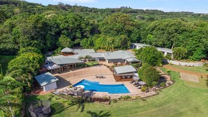 A residential property with a swimming pool, patio area, and multiple buildings surrounded by dense forest. - Glenbrook House and Studio (Ewingsdale)