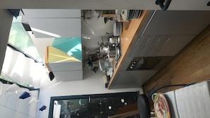 Una cocina moderna con un ventanal grande, un comedor con mesa y sillas, y vistas al exterior.