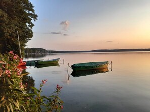 A calm lake with boats docked, surrounded by trees and vegetation. - Holiday Villa With a Garden, Close to the Lake (Stawiguda)