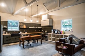 A modern kitchen with a dining area, bar, and seating.