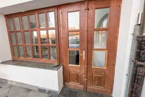 A wooden double door with glass panels, a small step leading to the entrance, and a metal structure to the right. - Riverside Ljubljanica With Parking 3 (Ljubljana)