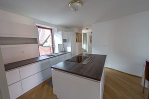 A modern kitchen with white cabinets, a wooden countertop, and a built-in stove. - Riverside Ljubljanica With Parking 3 (Ljubljana)