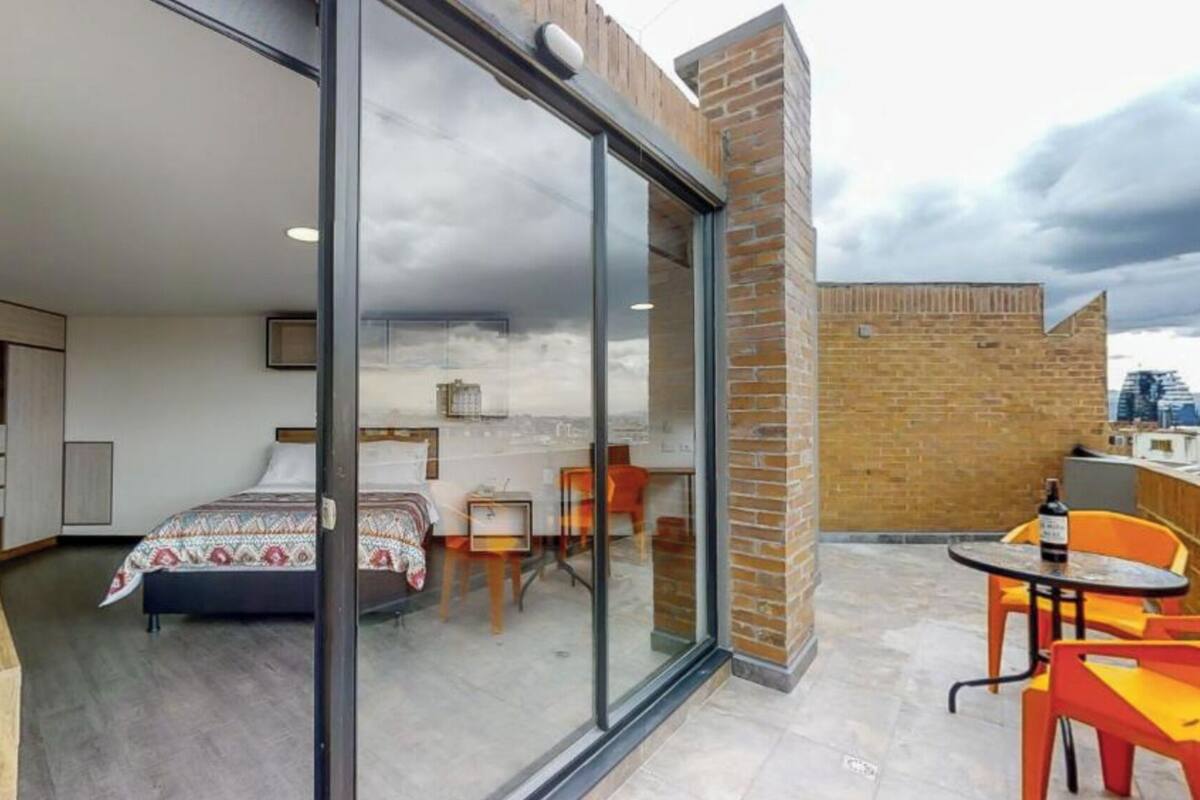 Une chambre à coucher moderne avec un lit, une petite table et une chaise.