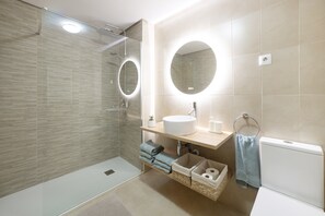 A modern bathroom with a glass shower enclosure, a round mirror, a sink, and a toilet. - Ground Floor Apartment 'Ullastre' in Torre Golf Resort (Torre-Pacheco)