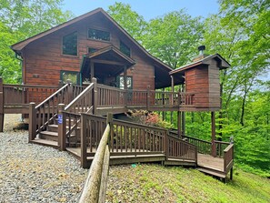 A wooden cabin with a porch, a staircase, and a small tower-like structure. - A Bear's Eye View - Pet Friendly | Mountain View | Hot Tub | Game Room (Blue Ridge)