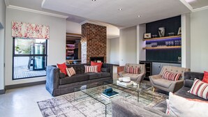 Ein modernes Wohnzimmer mit Kamin, Sofas, Couchtisch und Bücherregal.