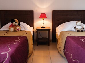 A hotel room with two beds, each with a plush toy, a bedside table with a lamp, and a wall socket. - Duplex Maisonette in Dordogne (Bergerac)
