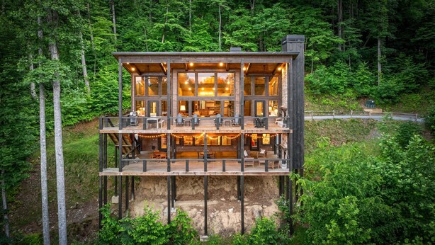 A multi-level wooden cabin with outdoor seating and a view of the forest. - The Day Hike - Pet Friendly | Mountain View | Outdoor Fireplace | Oversized Deck (Blue Ridge)