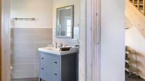 Een badkamer met een wastafel, spiegel en handdoekhouder.