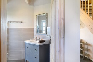 A bathroom with a sink, mirror, and towel rack. - Swedish Cottage Zierow - Baltic Sea - House 16b (Zierow)