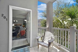 A balcony with a chair, a door leading to a room, and a number '201' on the wall. - 3 bedroom two bath with a community pool. Sleeps 7. (Saint Simons Island)