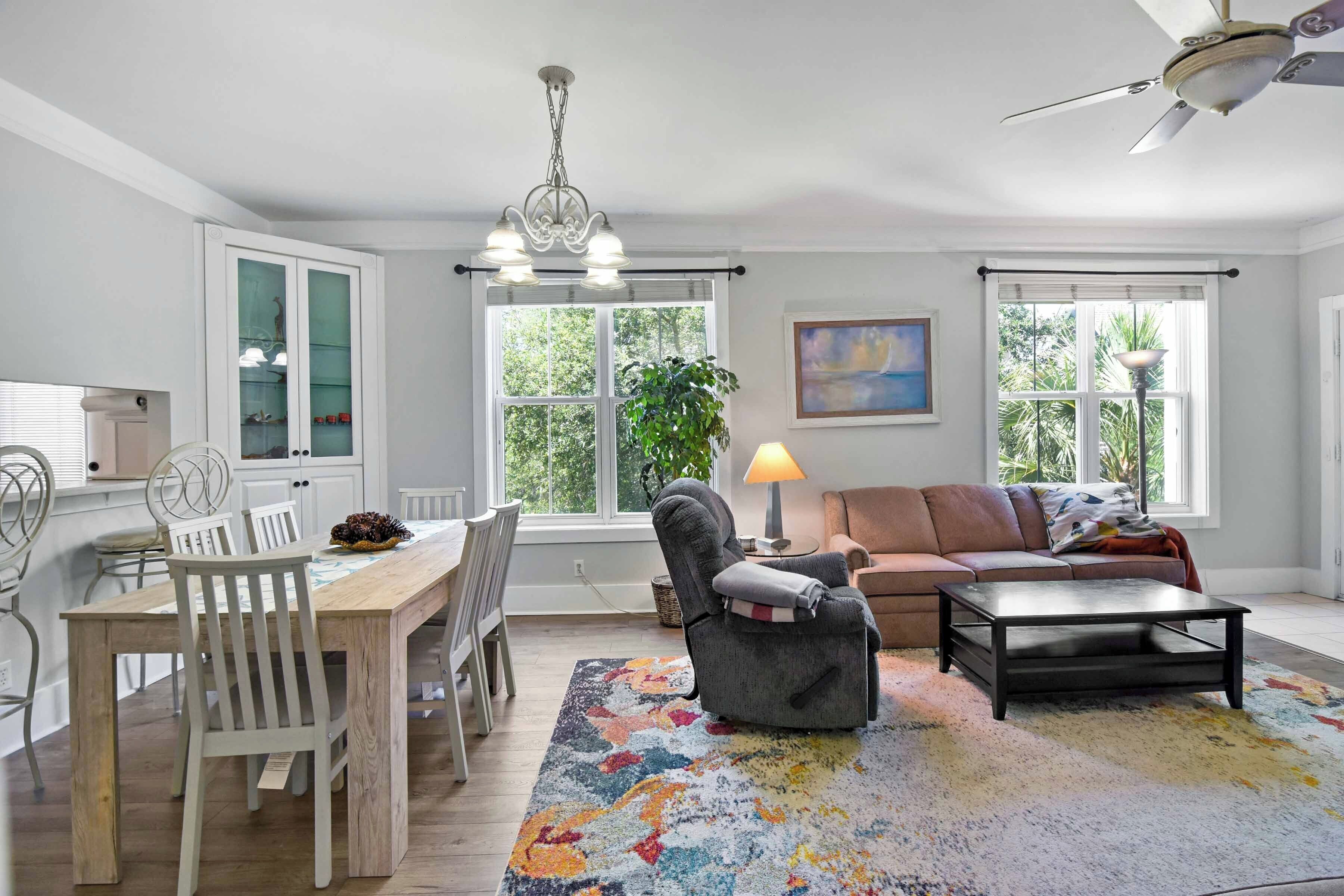 A spacious living room with a dining area, a sofa, a coffee table, and a chandelier.