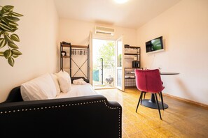 Una camera da letto con un letto, una scrivania con una sedia, una televisione e vista all'esterno.