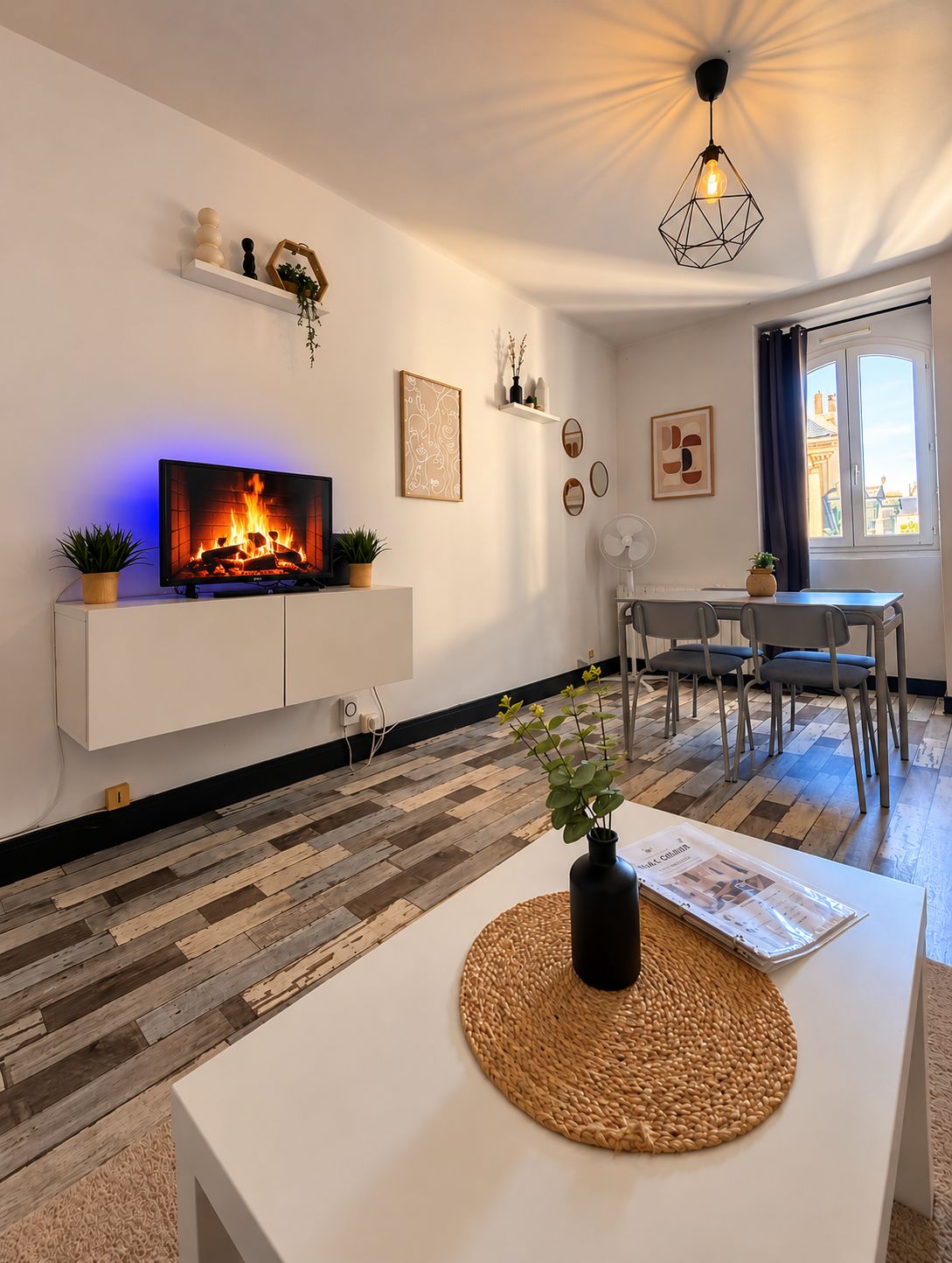 A modern living room with a fireplace, white furniture, and a dining area with chairs.