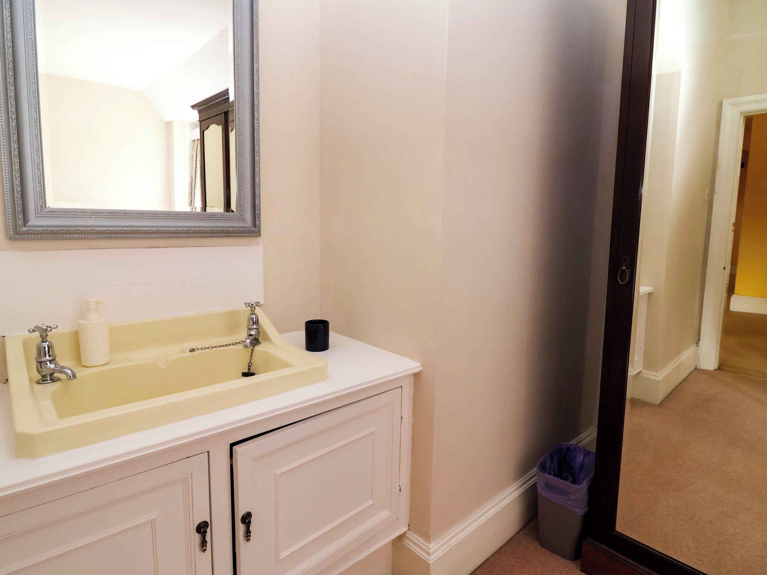 Un bagno con lavandino, specchio e mobili.