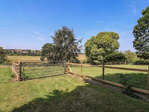 A fenced property with a gate, trees, and open fields. - Parkfields House (Stoke-on-Trent)